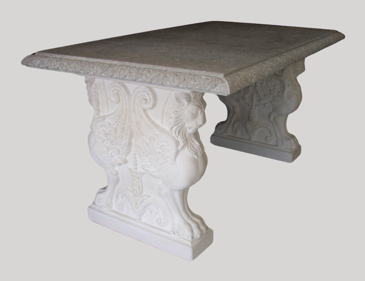 Tavolo in pietra decorato e basi con leoni alati